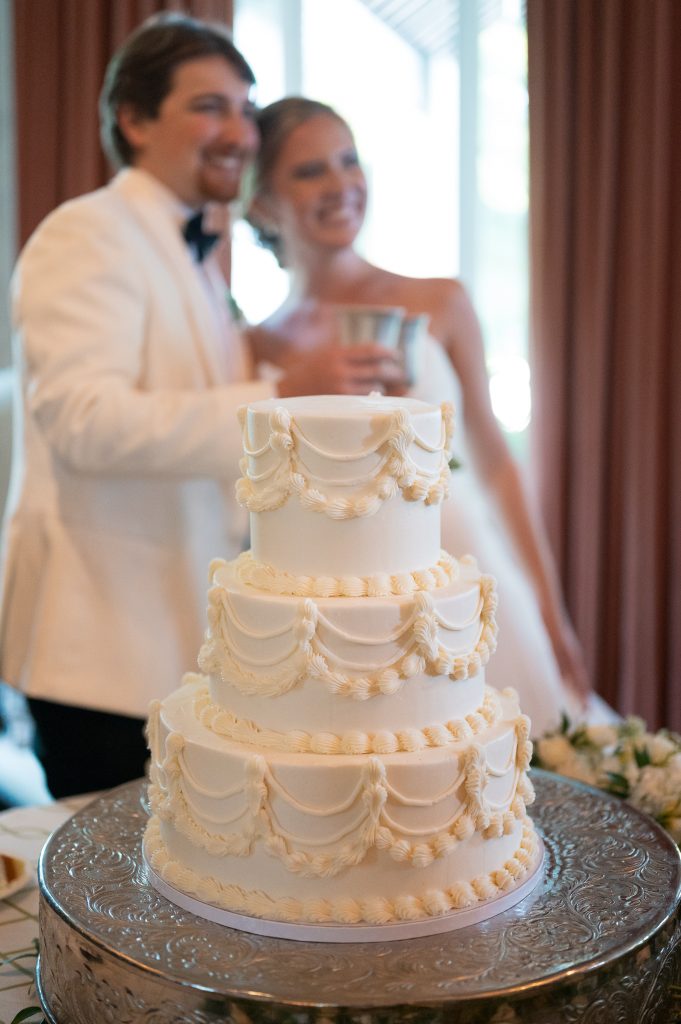 A decorative wedding cake in front of a couple at their wedding